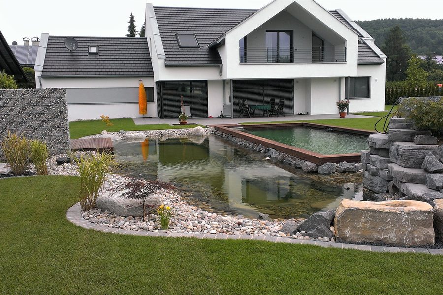 Schwimmteich in Kleinwallstadt mit Natursteinufer vor einem Wohnhaus